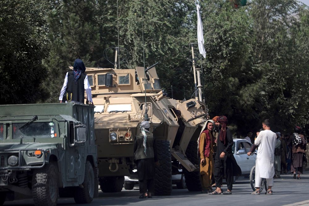 Des talibans montent la garde sur la route de l'aéroport international Hamid Karzai, à Kaboul, en Afghanistan, le 16 août 2021