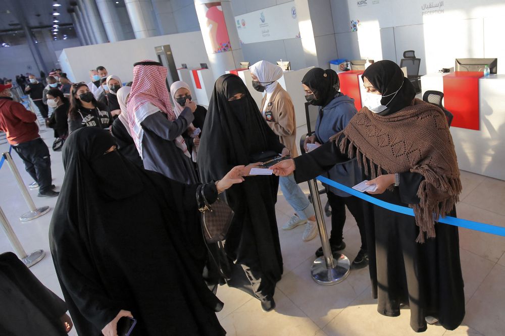 People are directed toward vaccination booths as they arrive to receive Covid-19 coronavirus vaccine booster doses at the vaccination center at the Kuwait International Fairground in Kuwait City on January 3, 2022.