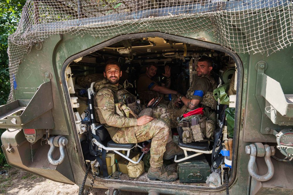 Ukrainian servicemen sit inside their APC after returning from Russian Kursk region, near Russian-Ukrainian border, Sumy region, Ukraine