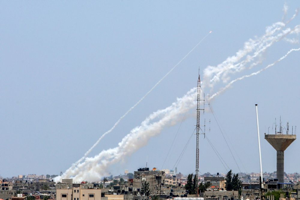 Des traînées de fumée sont visibles alors que des roquettes sont tirées depuis la bande de Gaza vers Israël, à Khan Younis, le 13 mai 2023