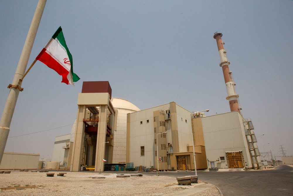 Iranian flag flutters in front of the reactor building of the Bushehr nuclear power plant.