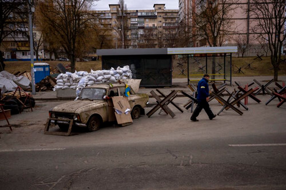 A militiaman walks in a checkpoint set up at a road heading to the city of Kyiv, Ukraine, March 5, 2022.