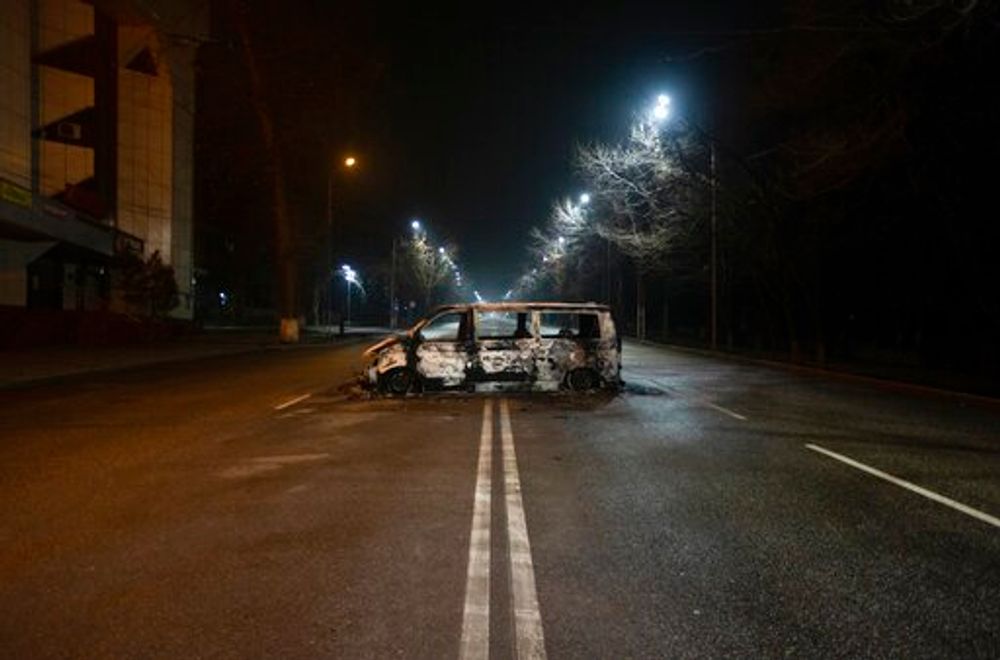 A police van, which was burned after clashes, remains in an empty street in Almaty, Kazakhstan, January 8, 2022.