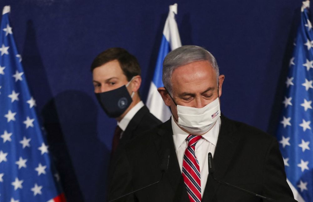 Benjamin Netanyahu stands at his podium ahead of a press conference with Jared Kushner (L) in Jerusalem on December 21, 2020.