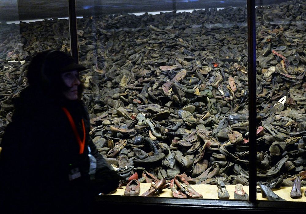 Une visiteuse passe devant les chaussures des prisonniers exposées sur le site commémoratif de l'ancien camp de concentration d'Auschwitz en Pologne, le 26 janvier 2015