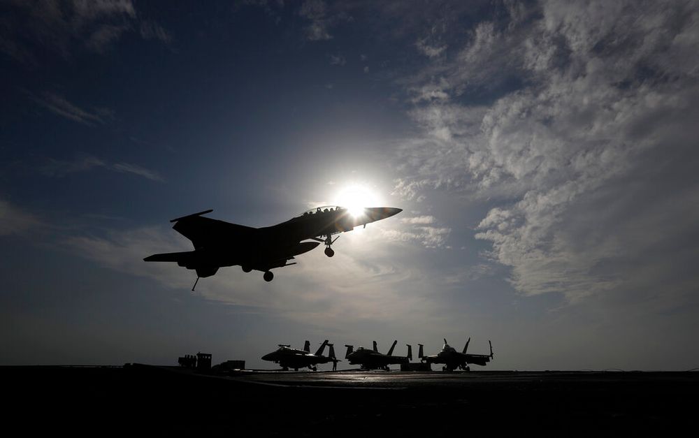 A U.S. Navy fighter jet lands on the deck of the U.S.S. Dwight D. Eisenhower aircraft carrier.