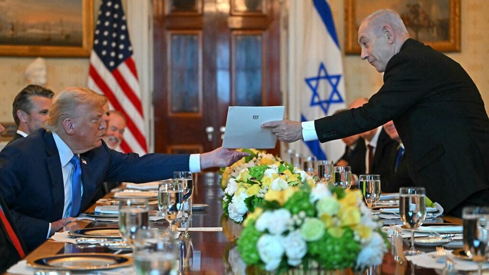 Netanyahu hands over a letter to Trump as they meet at the Blue Room of the White House in Washington, DC, on July 7, 2025.