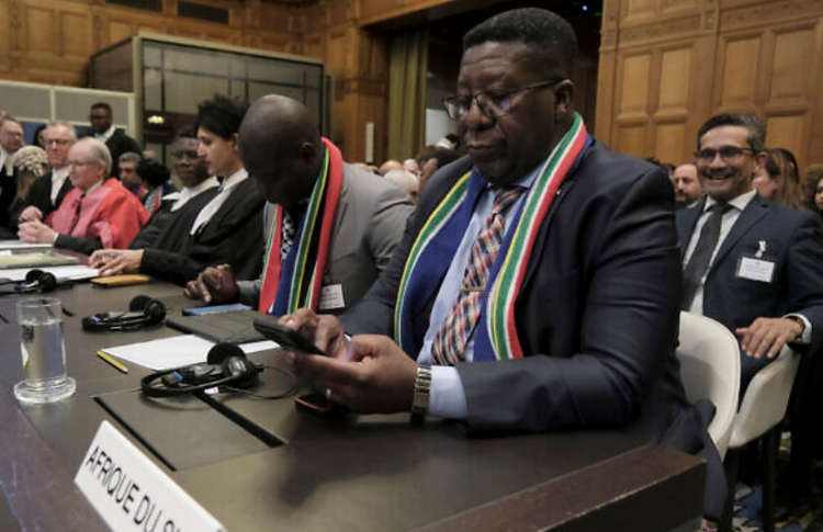 L'ambassadeur de la République d'Afrique du Sud aux Pays-Bas, Vusimuzi Madonsela, consulte son téléphone lors d'une audience à la Cour internationale de justice de La Haye (Pays-Bas), le 12 janvier 2024.