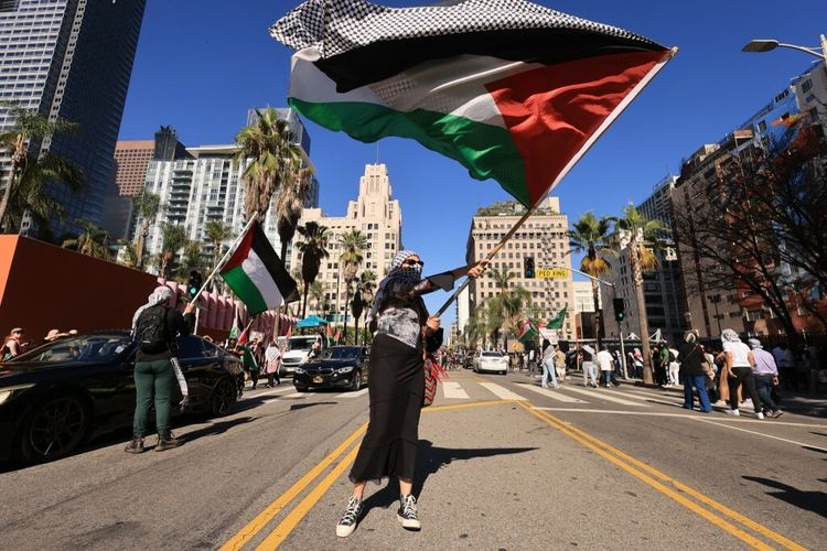 A protestor waves a Palestinian flag as people rally in support of Palestinians in Los Angeles, California on October 21, 2023.