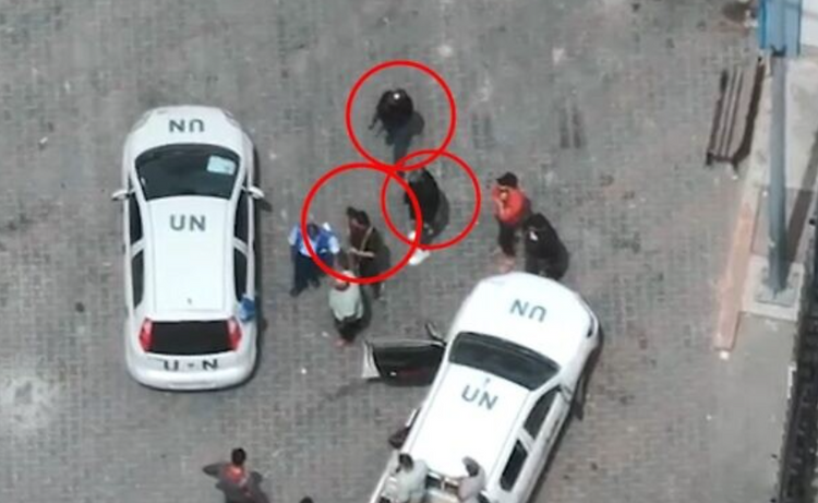 Une capture d'écran d'une vidéo de drone publiée par l'IDF le 14 mai 2024, montre des terroristes palestiniens à côté de véhicules de l'ONU dans un centre logistique de l'UNRWA à Rafah