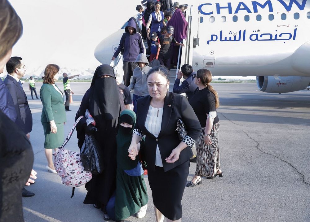 Refugees disembark a plane at an airport in Dushanbe, Tajikistan.