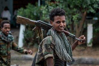 Fighters loyal to the Tigray People's Liberation Front (TPLF) walk along a street in the town of Hawzen, then controlled by the group, in the Tigray region of northern Ethiopia, May 7, 2021.