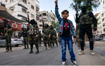 Les enfants se tiennent avec les terroristes du Hamas alors qu'ils défilent dans les rues pour Bassem Issa, un haut commandant du Hamas, qui a été tué par l'armée israélienne  le samedi 22 mai 2021.