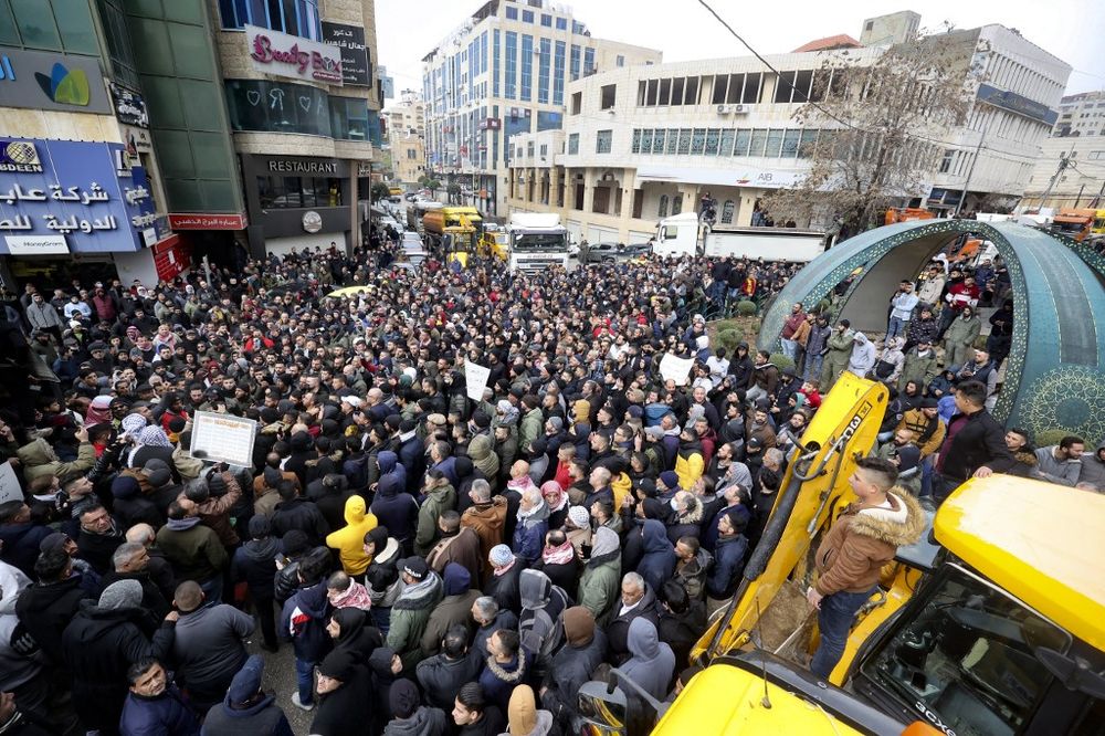 Trucks block a main boulevard as people gather to protest against the Palestinian Authority, high taxes and the cost of living, in the West Bank town of Hebron, on February 6, 2022.