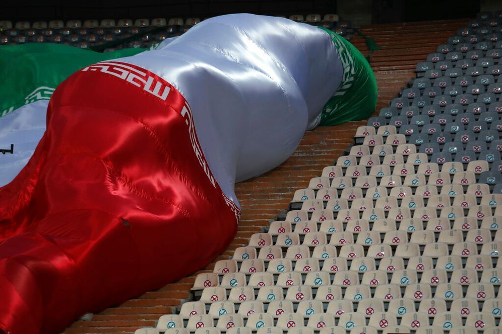 An Iranian flag waves next to empty seats during an Iran vs. UAE soccer match in Tehran, Iran.