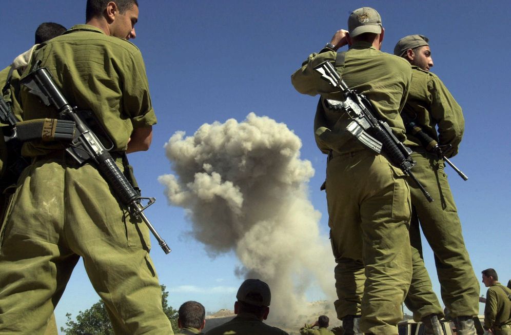 Soldiers watch as the Pzitoren Israeli military outpost is blown up in the northwestern communal farm of Manara, on May 29, 2000, days after Israel withdrew its last soldier