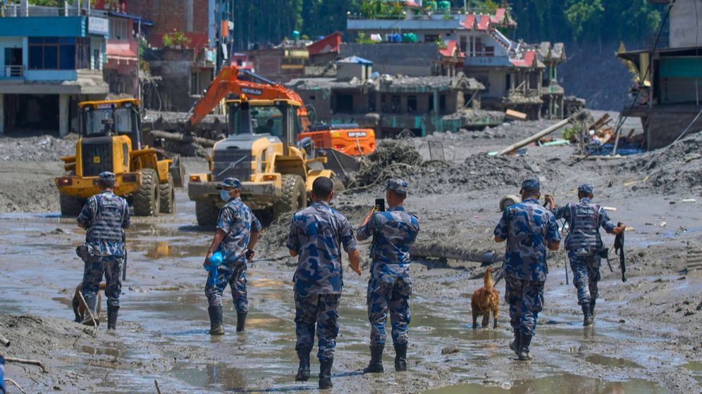 Des policiers népalais et des engins de terrassement en train de déblayer les débris laissés par les inondations, au Népal, le 27 août 2026

