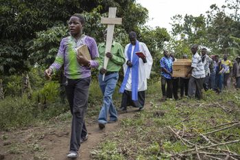 A pastor leads the funeral of Florence Masika and Zakayo Masereka during their burial rituals in Mpondwe, Uganda, after terrorists killed dozens of students in a school attack.