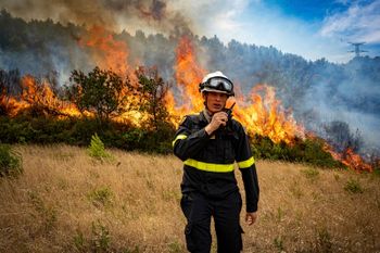 This photo, provided by the Securite Civile on Thursday Aug. 7, 2025, shows a rescuer from the Securite Civile next the wildfire near Saint-Laurent-de-la-Cabrerisse, southern France, Wednesday, Aug. 6, 2025. (Securite Civile via AP)
