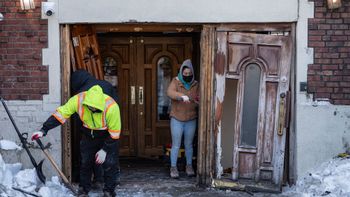 Des personnes nettoient les lieux où une voiture a percuté l'entrée du siège mondial du mouvement Habad, le 29.01.2026, à New York.
