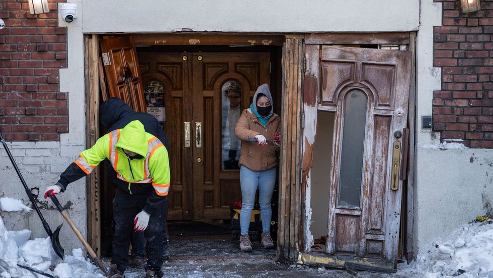 People clean up the scene where a car crashed into the entrance of the Chabad movement's world headquarters on January 29, 2026, in New York.