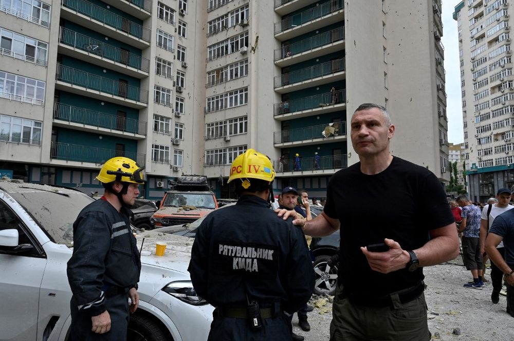 Kyiv's Mayor Vitali Klitschko talks with rescuers next to a 24-storey building partially destroyed following a Russian missiles strike in Kyiv, Ukraine.