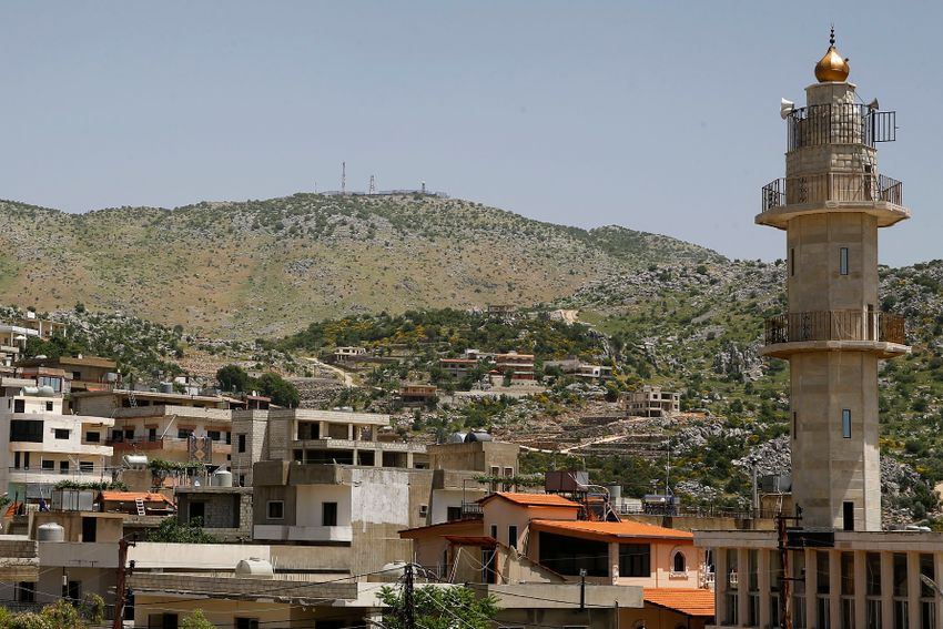 DOSSIER - Un poste militaire israélien au sommet du mont Hermon dans les hauteurs du Golan contrôlées par Israël est vu du village de Kfar Chouba, où les frontières israélo-syro-libanaises se rejoignent, dans le sud-est du Liban, le 20 mai 2020.