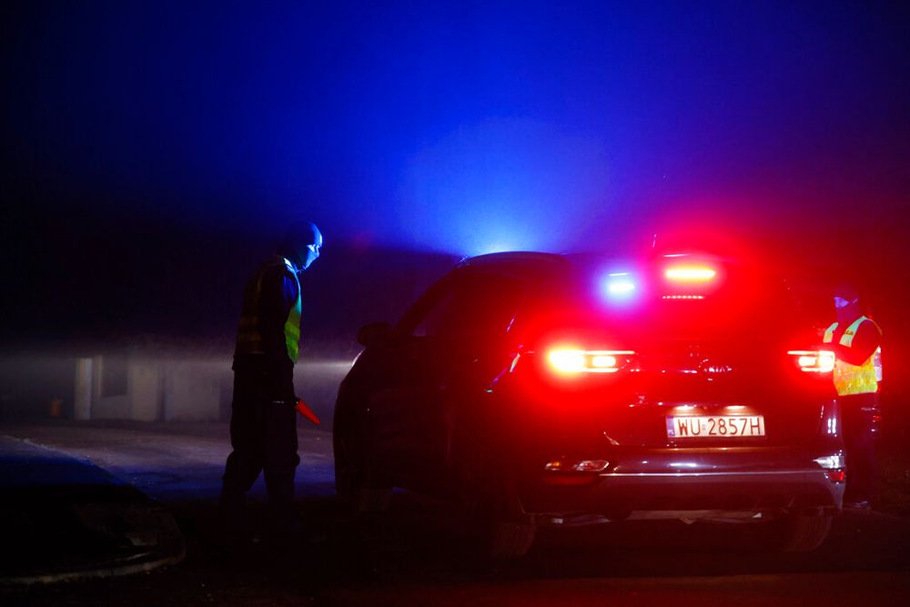A police officer checks a vehicle outside a grain depot where, according to the Polish government, an explosion of a Russian-made missile killed two people, in Przewodow, eastern Poland