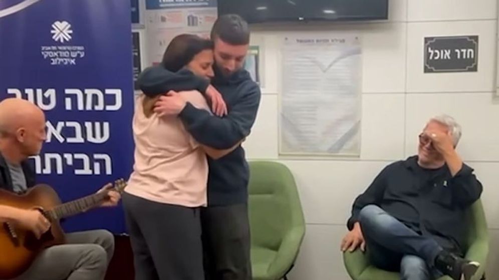 שורד השבי מתן אנגרסט מחובק עם אמו ענת, כאשר ברקע שר שלמה ארצי ומנגן  אבי סינגולדה