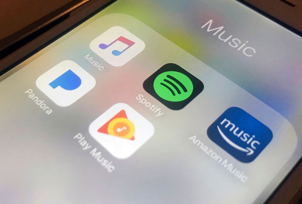 This file photo shows music streaming apps clockwise from top left, Apple, Spotify, Amazon, Pandora and Google on an iPhone in New York, USA.