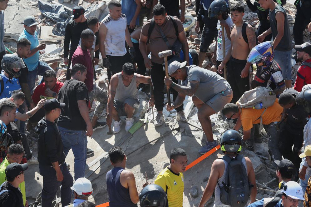 Residents search for survivors in the rubble after an earthquake struck Cali, Colombia, Monday, Aug. 10, 2026
