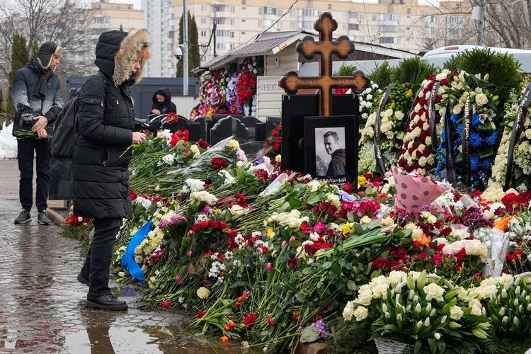 A woman lays flowers at the grave of Alexei Navalny in Moscow, Russia, March 2, 2024. Navalny, who was President Vladimir Putin's fiercest foe, was buried after a funeral that drew thousands of mourners amid a heavy police presence.