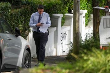 A police detective walks near houses vandalized with anti-Israel slogans in the Sydney suburb of Woollahra, Australia