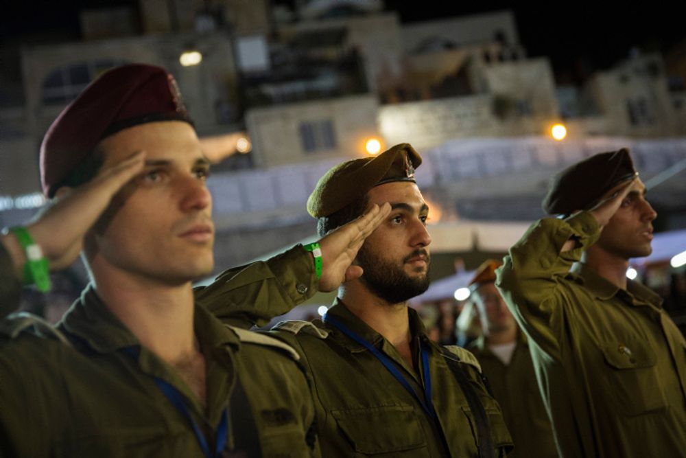 Israeli soldiers salute during the national anthem at a Memorial Day ceremony at the Western Wall in Jerusalem's Old City on May 10, 2016.