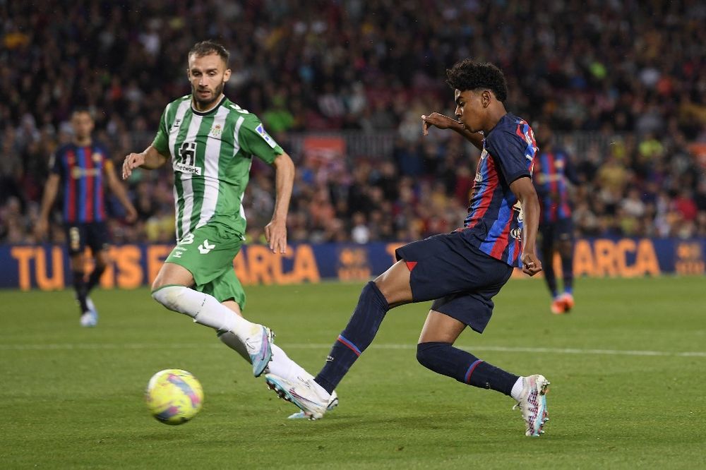 Real Betis' Argentinian defender German Pezzela vies with Barcelona's Spanish forward Lamine Yamal (R) during the Spanish league football match between FC Barcelona and Real Betis at the Camp Nou stadium in Barcelona