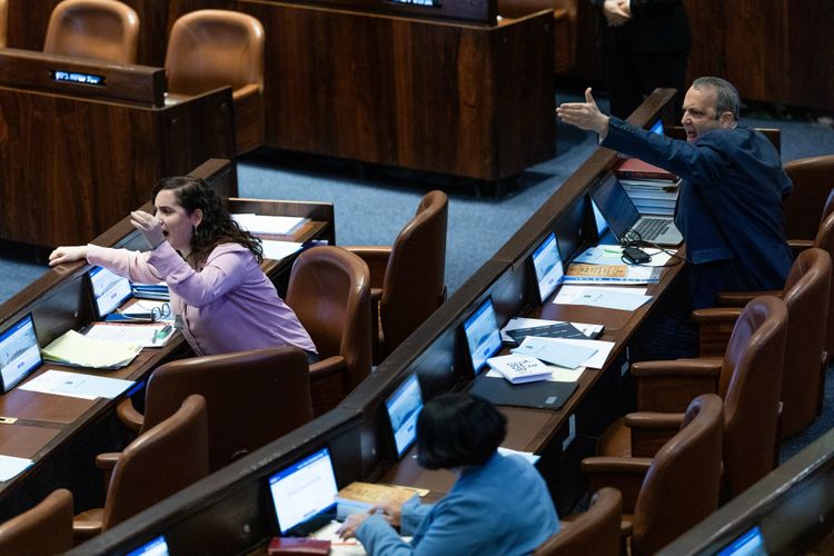 MK's Gilad Kariv and Naama Lazimi react during a plenum session at the assembly hall of the Knesset, the Israeli parliament in Jerusalem, on December 3, 2023