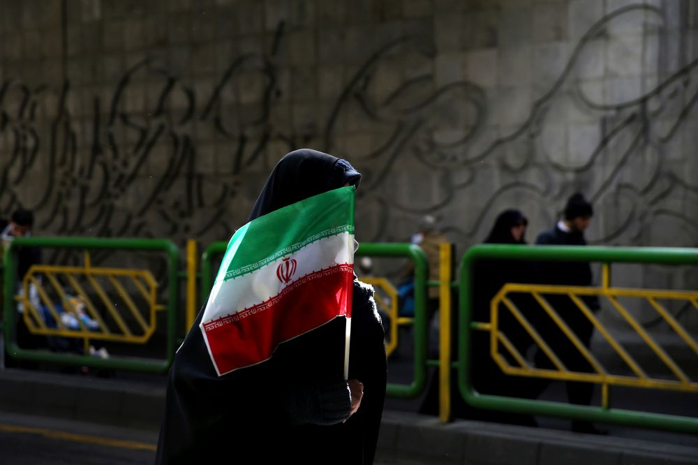 An Iranian woman holds the national flag during a rally commemorating the 37th anniversary of the Islamic Revolution, in Tehran, Iran, February 11, 2016.