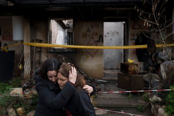 Amit Soussana, 40, right, is embraced by a friend after speaking to journalists in front of her destroyed house in the kibbutz Kfar Azza, near the Gaza Strip, Israel, Monday, Jan. 29, 2024. Soussana was held in captivity for 55 days after being kidnapped during the cross-border attack by Hamas on Oct. 7