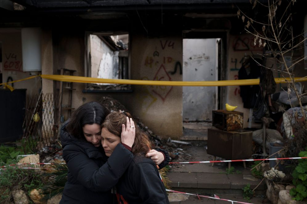 Amit Soussana, 40, right, is embraced by a friend after speaking to journalists in front of her destroyed house in the kibbutz Kfar Azza, near the Gaza Strip, Israel, Monday, Jan. 29, 2024. Soussana was held in captivity for 55 days after being kidnapped during the cross-border attack by Hamas on Oct. 7
