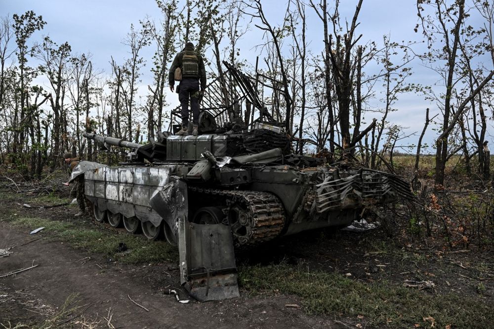 Ukranian soldier standing atop an abandoned Russian tank in eastern Ukraine.