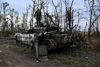 This photograph taken on September 11, 2022, shows a Ukranian soldier standing atop an abandoned Russian tank near a village on the outskirts of Izyum, Kharkiv Region, eastern Ukraine.