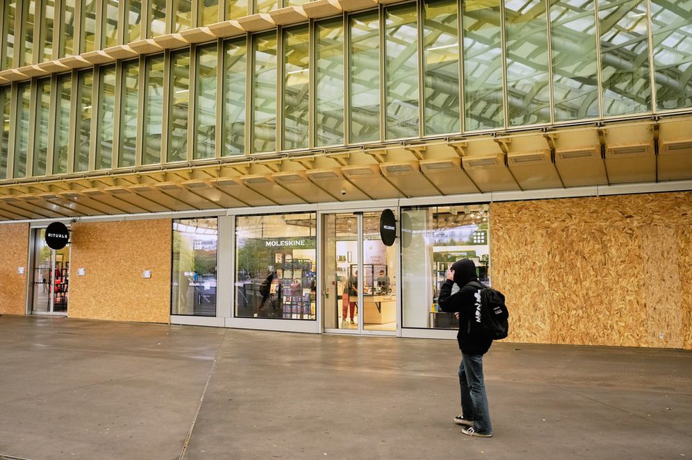 A man walks past stores boarded up with wooden planks in the Les Halles shopping district, which is under a nighttime curfew following weekend protests over the cost of living that turned into rioting and looting across France, in Paris, Wednesday, Oct. 21, 2026. 
