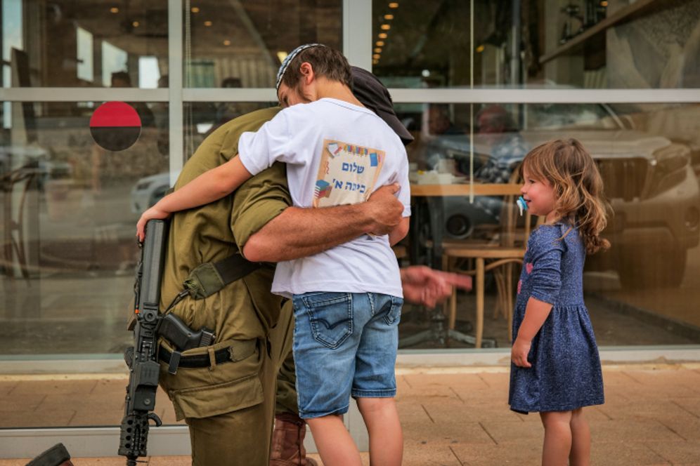 A reserve soldier reunites with his children who came to see him near the Lebanese border, October 18, 2023