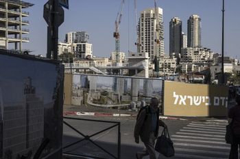 رجل يمر أمام إعلان لمبنى جديد في غرب القدس في 24 نوفمبر 2025.