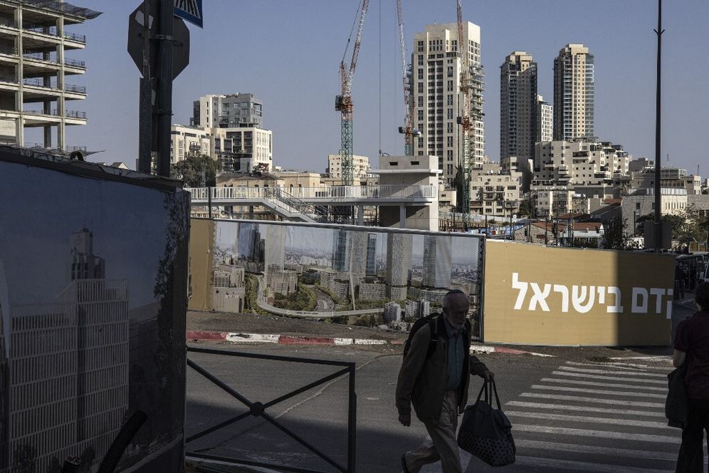 رجل يمر أمام إعلان لمبنى جديد في غرب القدس في 24 نوفمبر 2025.