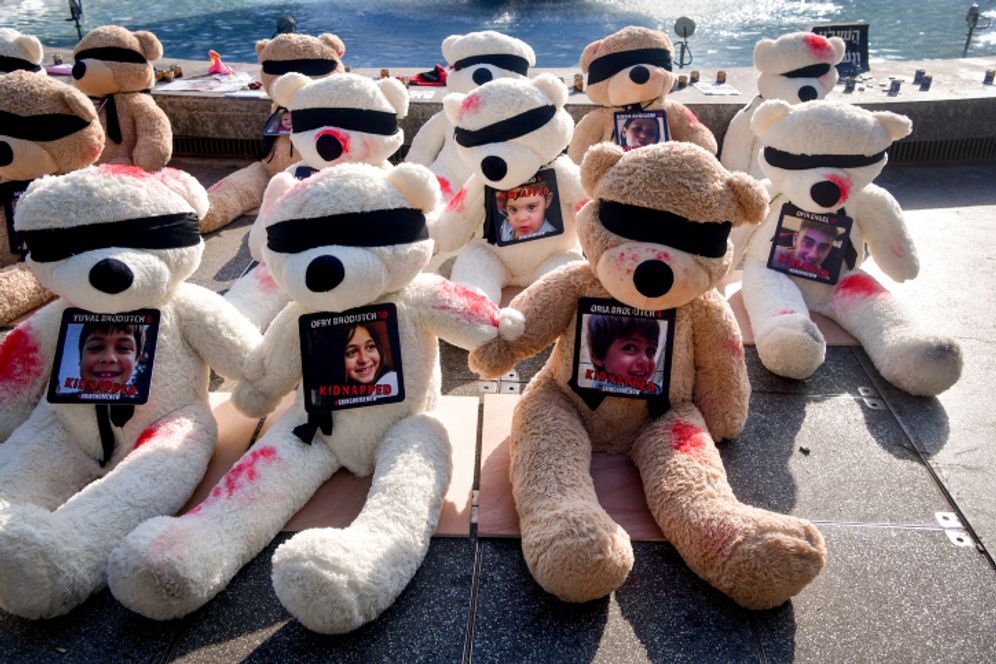 Large teddy bears painted with red paint and carrying photographs of the children held hostages by Hamas terrorists in Gaza, seen on Dizengoff Square, in Tel Aviv, Israel.