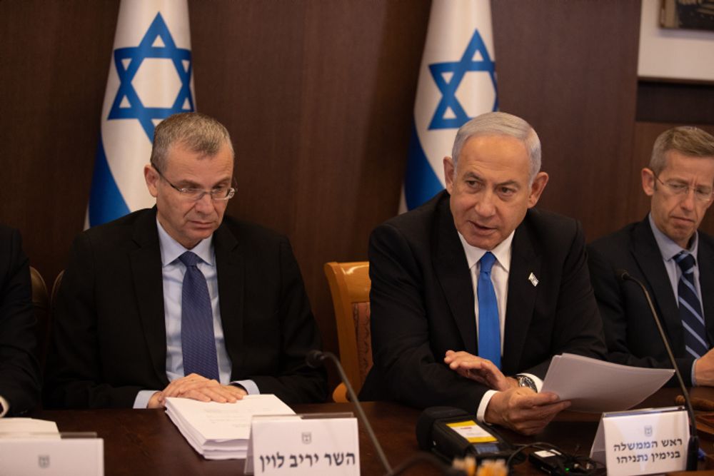 Israel's Justice Minister Yariv Levin (L) and Prime Minister Benjamin Netanyahu (C) at a government cabinet meeting.