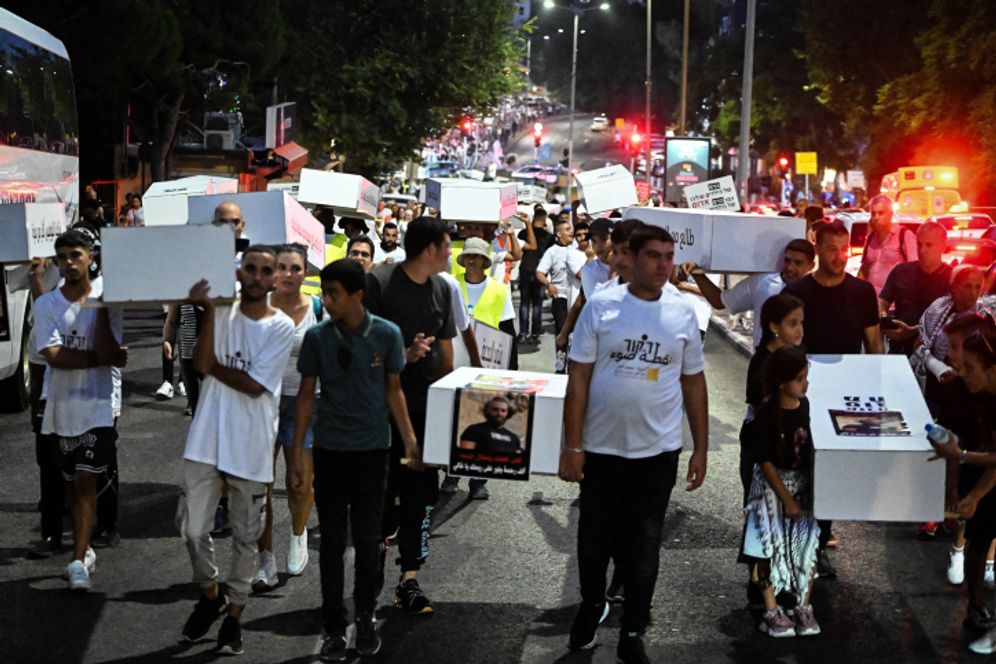 Members of the Arab community march as they protest against the violence in their community, in the northern city of Haifa, Israel.