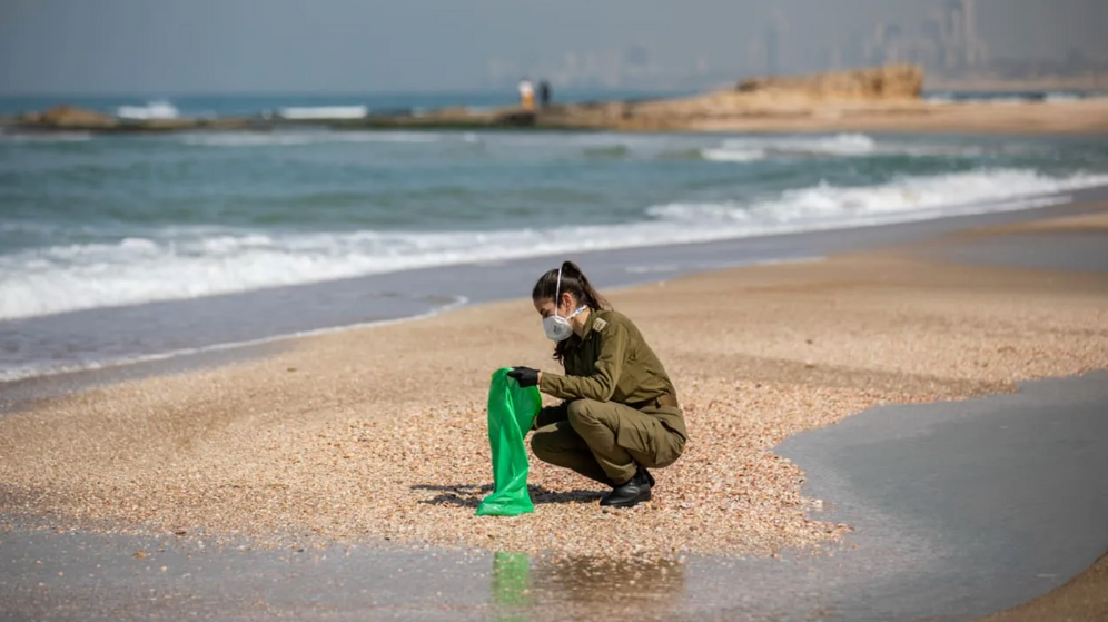 (photo credit: YONATAN SINDEL/FLASH 90 ) Israeli soldiers clean tar off the Palmachim beach following an offshore oil spill which drenched most of the Israeli coastline, February 22, 2021