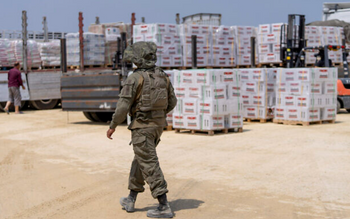 Un soldat israélien traverse une zone d'inspection de camions transportant de l'aide humanitaire à destination de la bande de Gaza, le mercredi 1er mai 2024.